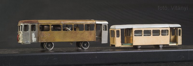 VI_FoDi_07_2160_s.jpg - 1000-es motorkocsi, és 5700-as pótkocsi. Az 56-os viszonylat jellegzetes szerelvénye a 80-as évek legelején. A modell anyagok és technikák kavalkádja: réz, alpakka, bakelit, műanyag, impregnált és ipregnálatlan papír. A pótkocsinak volt valaha futóműve, de nem vált be az ott alkalmazott módszer. Ez a modell sem fog már elkészülni: ha energiát szánnék rá, egyszerűbb lenne újra kezdeni, és szebb is lenne a végeredmény.